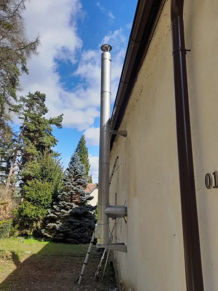 Nerezový komín vedený po fasádě rodinného domu u&nbsp;zahrady