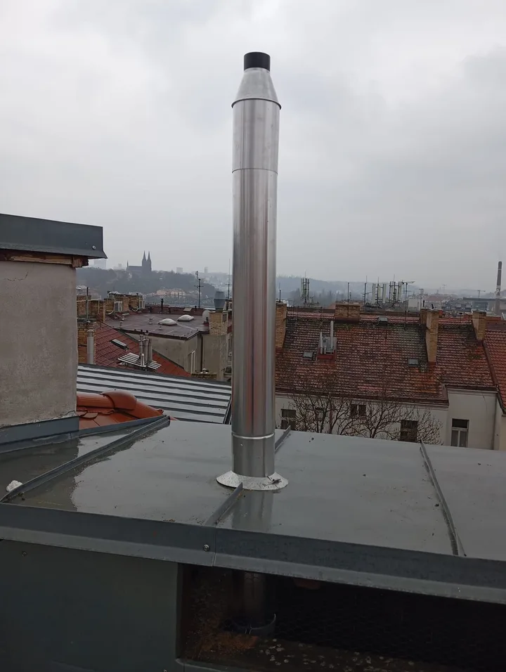 Nerezový komín na plechové střeše nástavby nad střechami Prahy