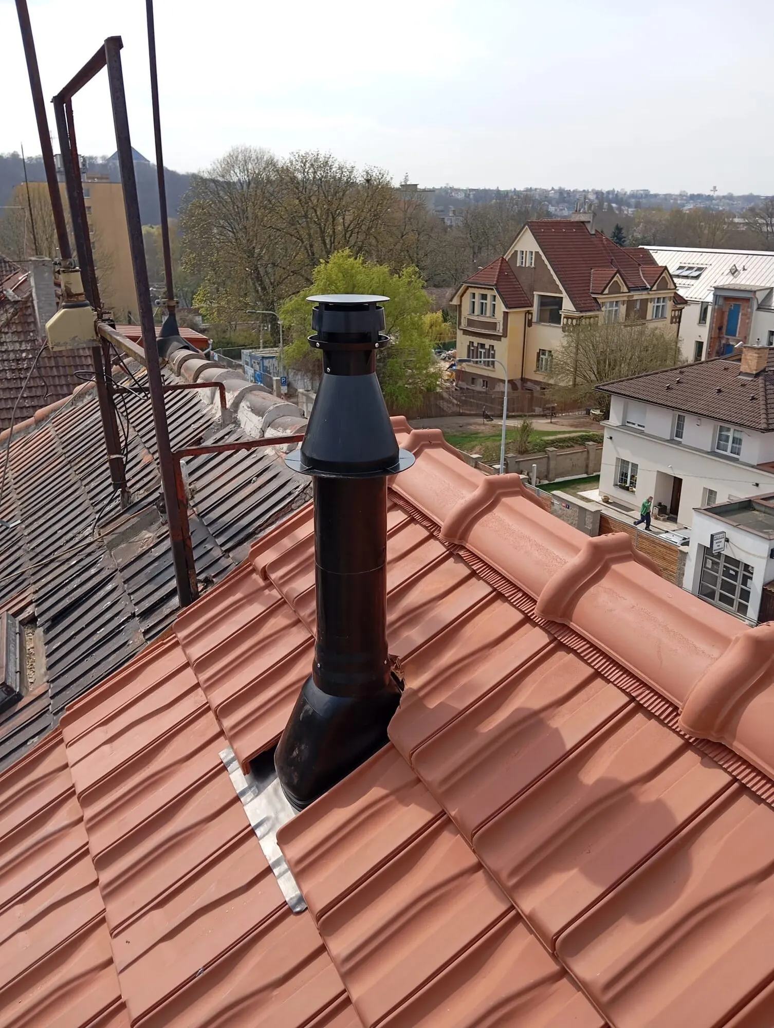 Odkouření kondenzačních kotlů vyvedené nad střechy rodinných domů ve vilové čtvrti